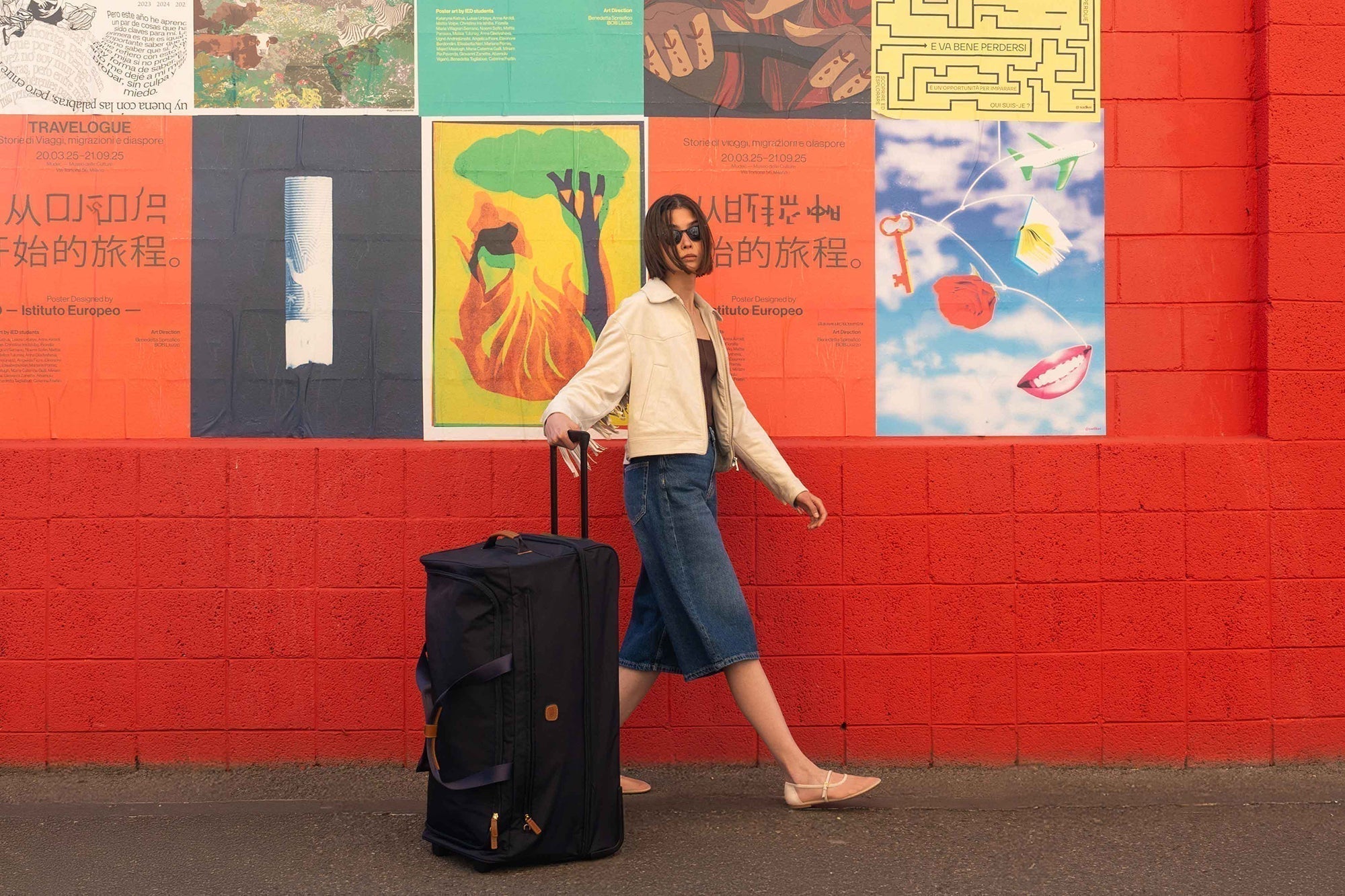 woman traveling with wheeled duffle bag - Bric's X-Collection rolling duffle luggage in navy blue